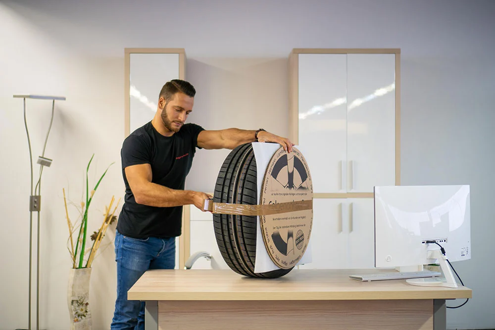 Kompletträder verpacken Schritt 1 - Reifen mit Klebeband fixieren für sicheren Versand